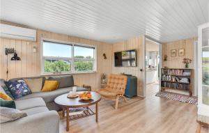 un soggiorno con un divano e un tavolo di Three-Bedroom Holiday Home In Juelsminde a Sønderby