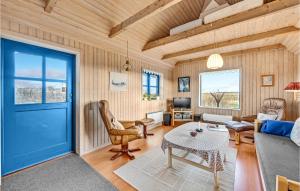 een woonkamer met een blauwe deur en een tafel bij 2 Bedroom Beautiful Home In Ulfborg in Fjand Gårde