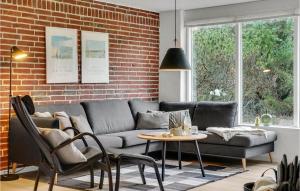 a living room with a couch and a brick wall at Beautiful Home In Ringkøbing With Wifi in Ringkøbing