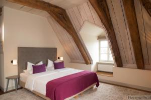 a bedroom with a large bed with purple pillows at Traditionshaus by Zollenspieker Fährhaus in Hamburg