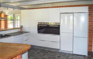 een keuken met witte apparatuur en een bakstenen muur bij Hjrnet in Sindal