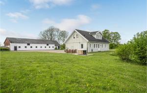 um grande campo de relva com dois edifícios brancos em 4 Bedroom Beautiful Home In Snder Stenderup em Sønder Stenderup