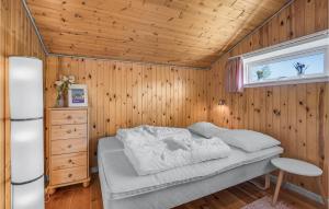EgernsundにあるBeautiful Home In Egernsund With 2 Bedrooms, Sauna And Wifiの木製の壁のベッドルーム1室(ベッド1台付)