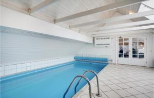 KlegodにあるStunning Home In Ringkbing With 4 Bedrooms, Sauna And Outdoor Swimming Poolの青い水と白いタイルの屋内スイミングプール