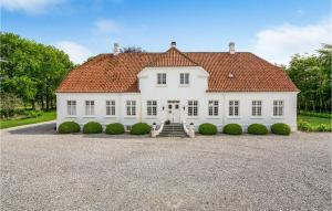 a large white house with a red roof at Rimersgaard in Horslunde