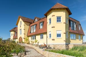 une grande maison jaune avec des toits bruns dans l'établissement Ferienwohnung Castellberg, à Heitersheim