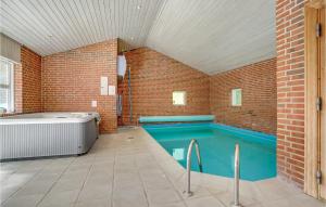 une piscine intérieure avec une baignoire et un mur en briques dans l'établissement Nice Home In Asperup With Sauna, à Asperup