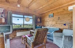 Cabaña de madera con sala de estar con sofá y TV. en 2 Bedroom Lovely Home In Faaborg, en Bøjden