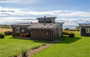 ein kleines Haus mit einem Dach auf einem Rasen in der Unterkunft Nice Home In Faaborg With House Sea View in Nabbe