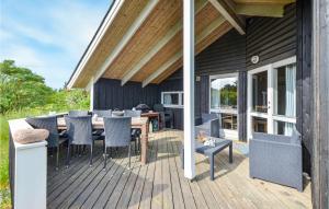 a wooden deck with a table and chairs on it at Stunning Home In Knebel With 3 Bedrooms, Sauna And Wifi in Knebel