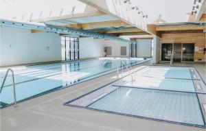 an indoor swimming pool with blue water in a building at Rejen 223 in Ebeltoft