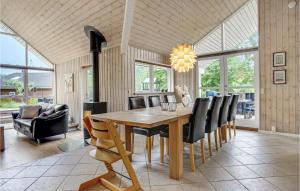 エーベルトフトにあるAmazing Home In Ebeltoft With 3 Bedrooms, Sauna And Wifiのダイニングルーム(木製テーブル、椅子付)