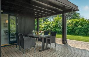 a patio with a table and chairs on a deck at Four-Bedroom Holiday Home In Tisvildeleje in Tisvildeleje
