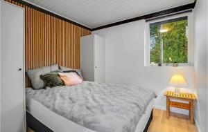 a small bedroom with a bed and a window at 3 Bedroom Amazing Home In Knebel in Knebel