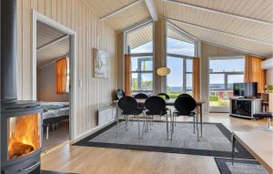 ein Wohnzimmer mit einem Tisch, Stühlen und einem Kamin in der Unterkunft Awesome Home In Sydals With Kitchen in Skovby