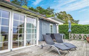 a patio with two chairs and an umbrella on a deck at Awesome Home In Ebeltoft With 2 Bedrooms in Ebeltoft