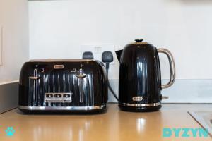 two black toasters sitting on top of a counter at The Lodge - DYZYN Living - GYM - Pool - Balcony - Parking - Cardiff Bay in Cardiff