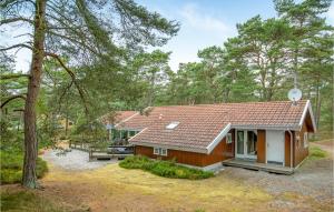 una pequeña casa en medio de un bosque en Beautiful Home In Nex With Sauna, en Spidsegård