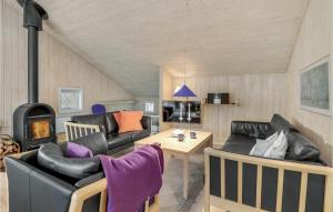 sala de estar con muebles de cuero y estufa de leña en Beautiful Home In Nex With Sauna, en Spidsegård