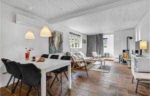 Amazing Home In Eg With Kitchen في Egå: مطبخ وغرفة معيشة مع طاولة وكراسي بيضاء