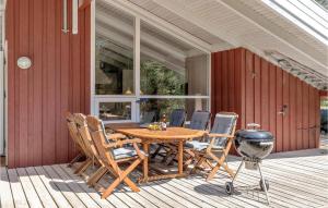 a wooden table and chairs on a porch with a grill at Godt Gemt in Vester Sømarken +18 photos
