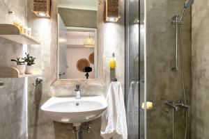 a bathroom with a sink and a shower at Amalgam Homes Paros Beachfront Villa in Ambelas