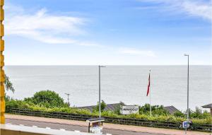 a view of the ocean with a bench and a flag at 2 Bedroom Stunning Apartment In Allinge in Allinge