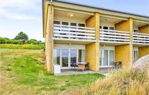 a yellow house with a table and chairs in front of it at 2 Bedroom Stunning Apartment In Allinge in Allinge