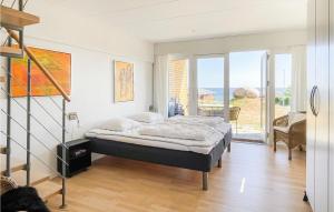 a bedroom with a bed and a balcony at 2 Bedroom Stunning Apartment In Allinge in Allinge