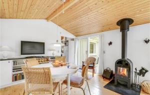 3 Bedroom Stunning Home In Hadsund في Hadsund: غرفة معيشة مع طاولة وموقد خشبي