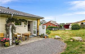 a house with a table and a chair in a yard at 2 Bedroom Stunning Apartment In Allinge in Allinge