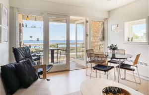a living room with a table and chairs and a view of the ocean at 2 Bedroom Stunning Apartment In Allinge in Allinge