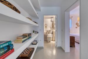 pokój z białymi ścianami i schodami z książkami w obiekcie Amalgam Homes Paros Beachfront Villa w mieście Ambelas