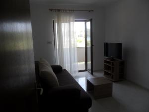 uma sala de estar com um sofá e uma televisão em Mar Eva Apartment em Rab