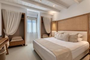 sypialnia z dużym łóżkiem i oknem w obiekcie Amalgam Homes Paros Beachfront Villa w mieście Ambelas