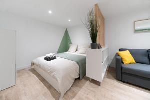 um pequeno quarto com uma cama e um sofá em ※Perrier Menthe※ Hyper-Centre et tranquillité em Clermont-Ferrand mais 30 fotografias