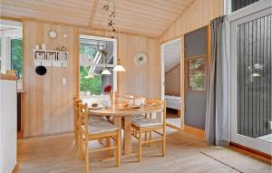a kitchen and dining room with a table and chairs at Holiday Home Mågelunden Rødby I in Kramnitse