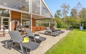 un grupo de sillas en un patio frente a un edificio en Amazing Home In Hadsund With 5 Bedrooms, Sauna And Wifi, en Helberskov