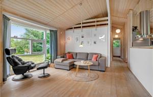 a living room with a couch and a chair at Holiday Home Mågelunden Rødby I in Kramnitse