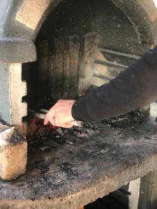 uma pessoa está a colocar comida num forno em Chalet 20 Min Far To Uludag Ski Resort em Çekirge