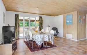 una sala da pranzo con un tavolo e una tv di Holiday Home Hvidkløvervej Ebeltoft a Ebeltoft
