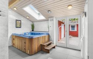 une grande salle de bains avec un bain à remous et une terrasse. dans l'établissement 5 Bedroom Amazing Home In Rrvig, à Rørvig