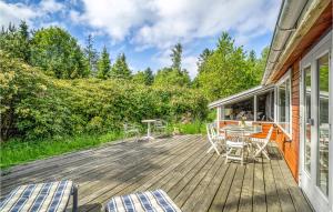 una terrazza in legno con tavolo e sedie. di 5 Bedroom Amazing Home In Rrvig a Rørvig