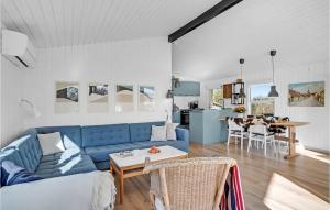 ein Wohnzimmer mit einem blauen Sofa und einer Küche in der Unterkunft Awesome Home In Nysted With House Sea View in Nysted