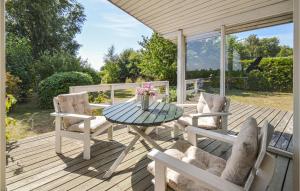 eine Terrasse mit einem Tisch und Stühlen auf einer Terrasse in der Unterkunft Awesome Home In Nysted With House Sea View in Nysted