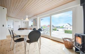 ein Esszimmer mit einem Tisch und Stühlen sowie einem großen Fenster in der Unterkunft Nice Home In Ebeltoft With House Sea View in Ebeltoft