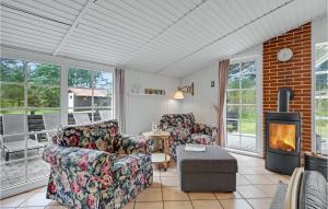 sala de estar con 2 sillas y chimenea en Stunning Home In Blvand With Wifi, en Blåvand