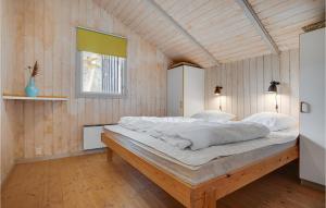 KnebelにあるNice Home In Knebel With 4 Bedrooms, Sauna And Wifiの木製の壁のベッドルーム1室(大型ベッド1台付)