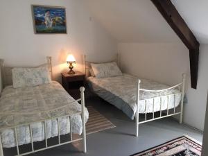 ein Schlafzimmer mit 2 Betten und einer Lampe auf einem Tisch in der Unterkunft La Cheneraie, A Peaceful, Rural Retreat in Ménéac
