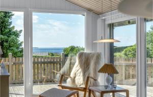 エーベルトフトにあるNice Home In Ebeltoft With 2 Bedrooms And Wifiの海を望む椅子付きのポーチ